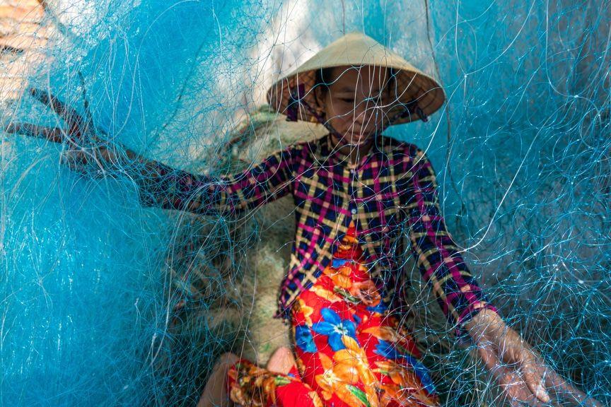 person surrounded by fishing nets