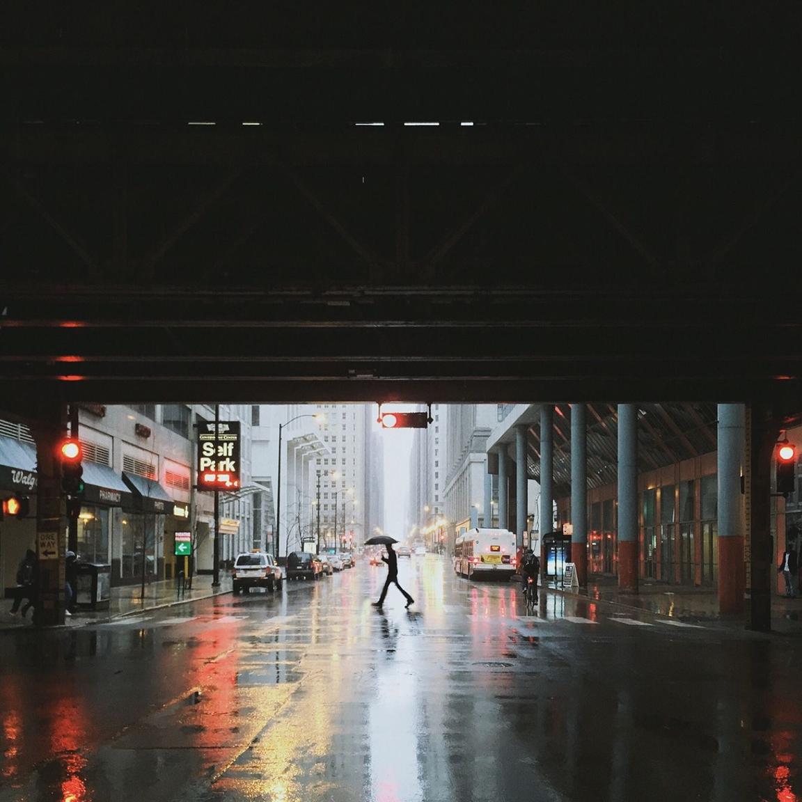 person crossing rainy city street