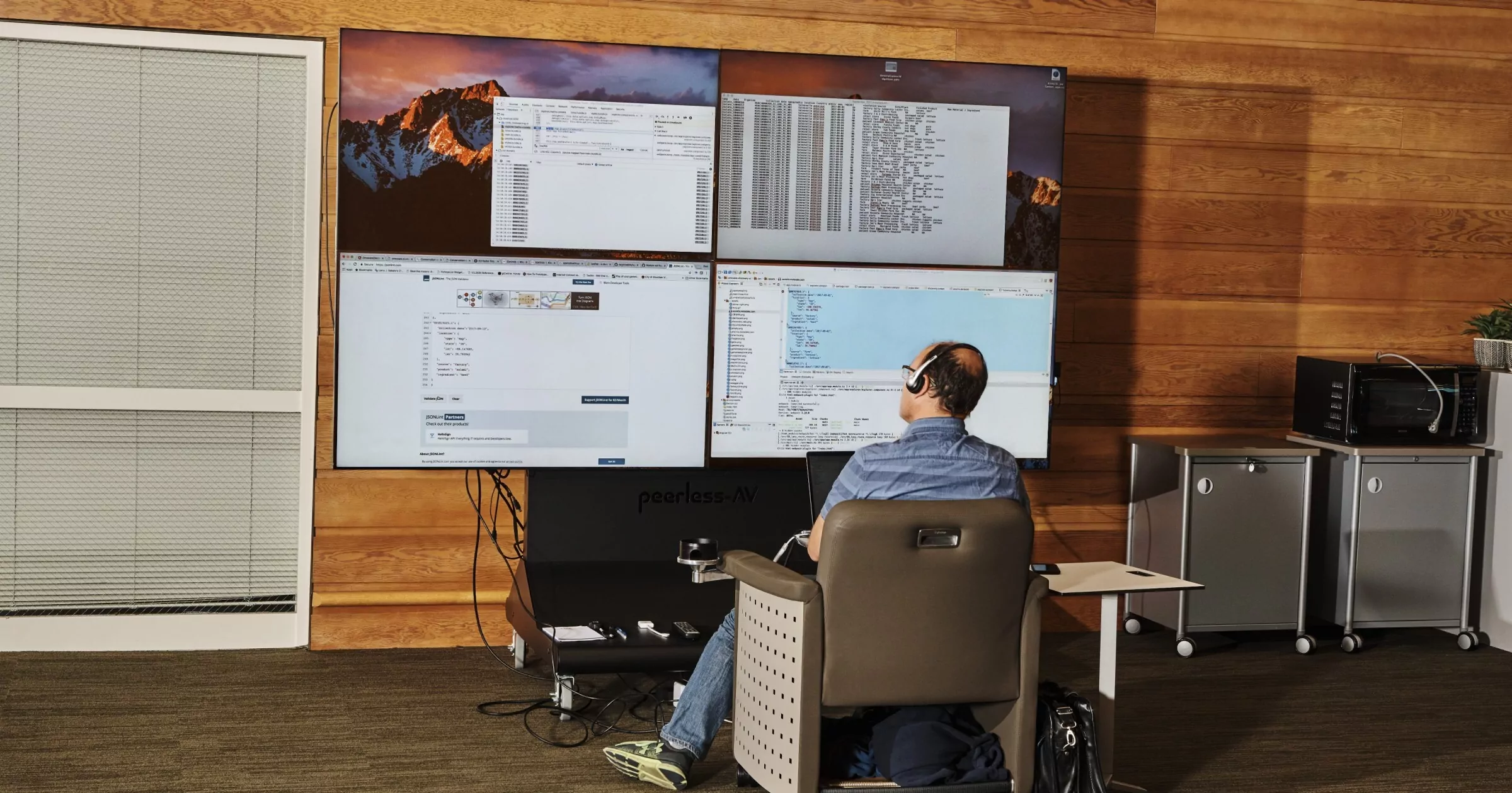 Developer looks at many monitors