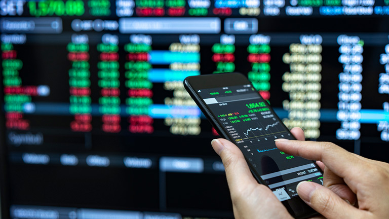 businesswoman using a mobile phone to check stock market data