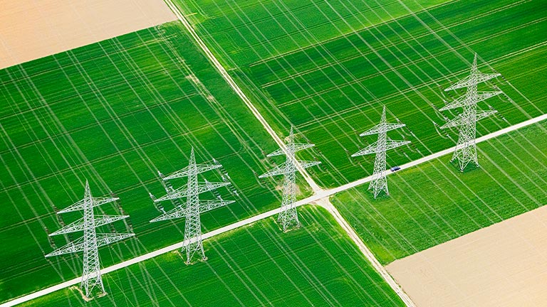 Aerial view of electrical utility lines in grassy field 