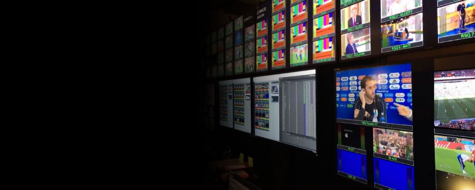 Grande parede de monitores exibindo transmissões esportivas e entrevistas
