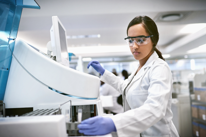 Lab technician with protective eye gear using lab equipment