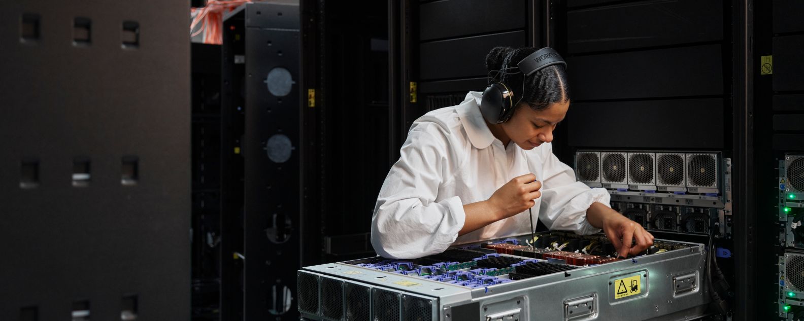 Person wearing headphones while working on computer equipment