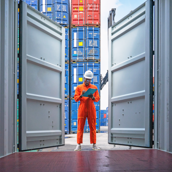 Worker checking inventory in shipping container