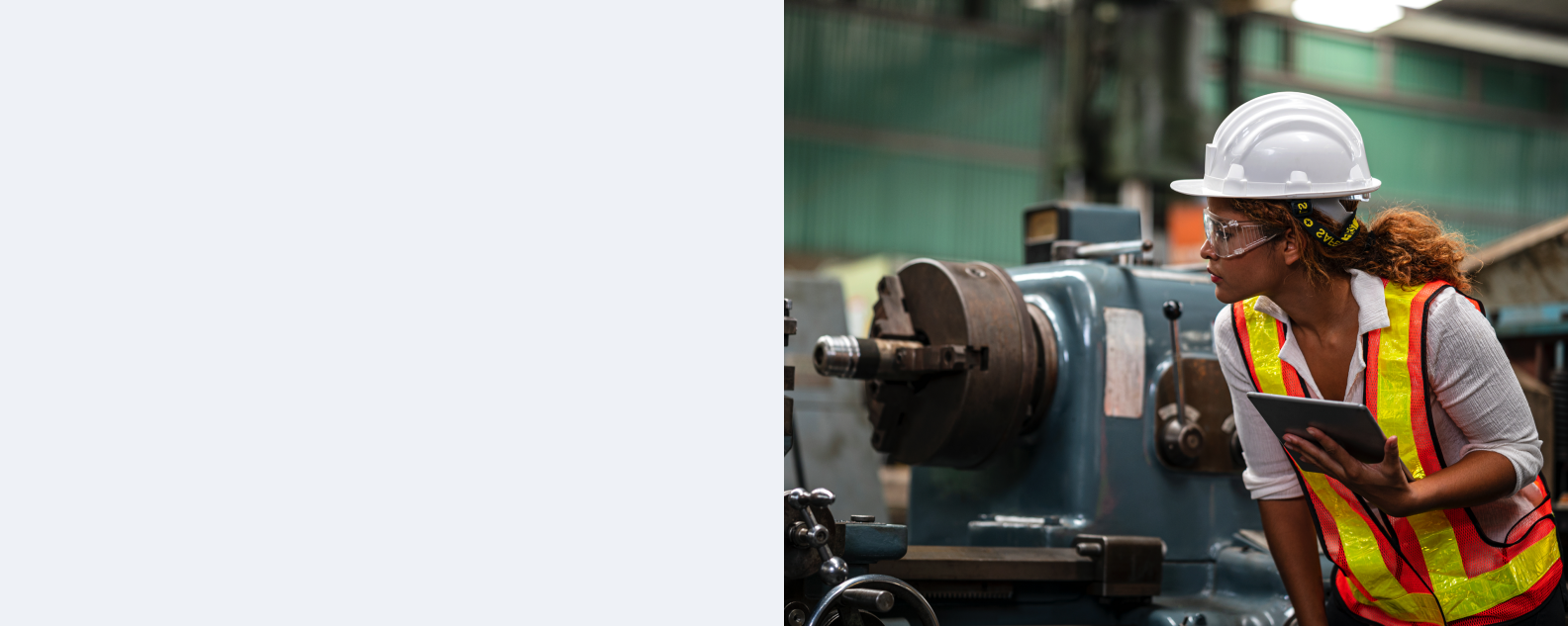 A person wearing safety gear inspects a piece of machinery