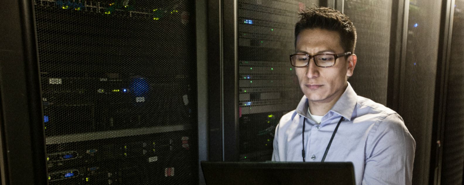 Hispanic man technician doing diagnostic tests on computer servers