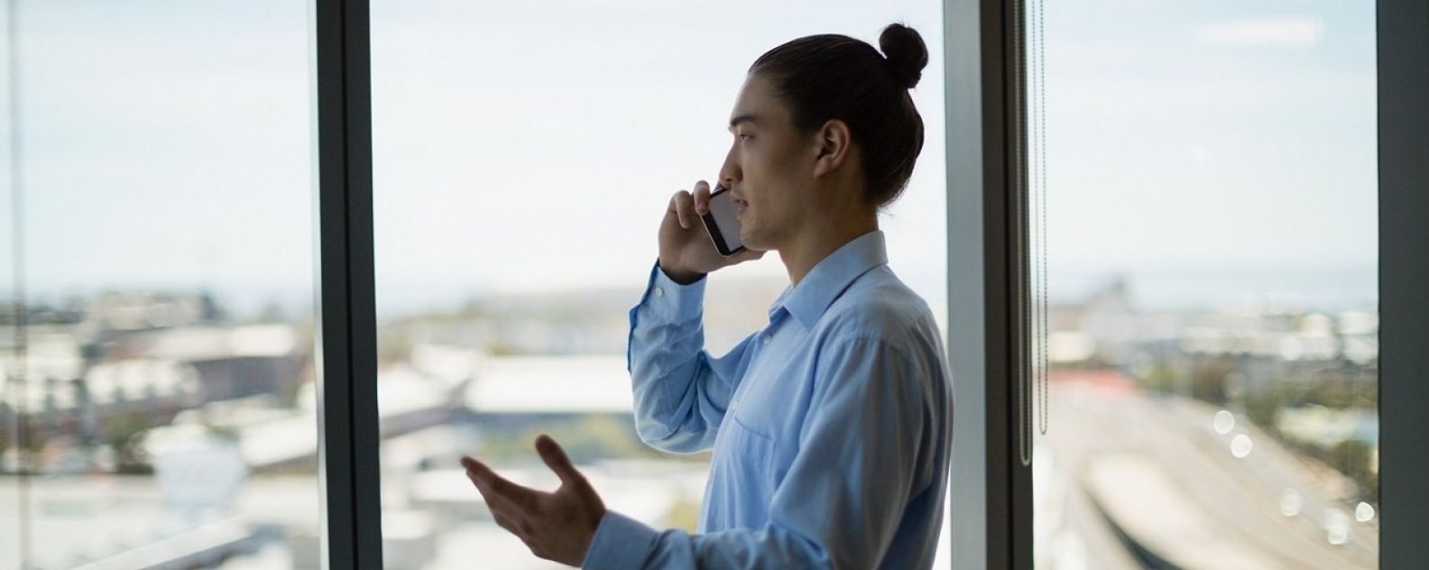 Business executive talking on mobile phone in corridor at office