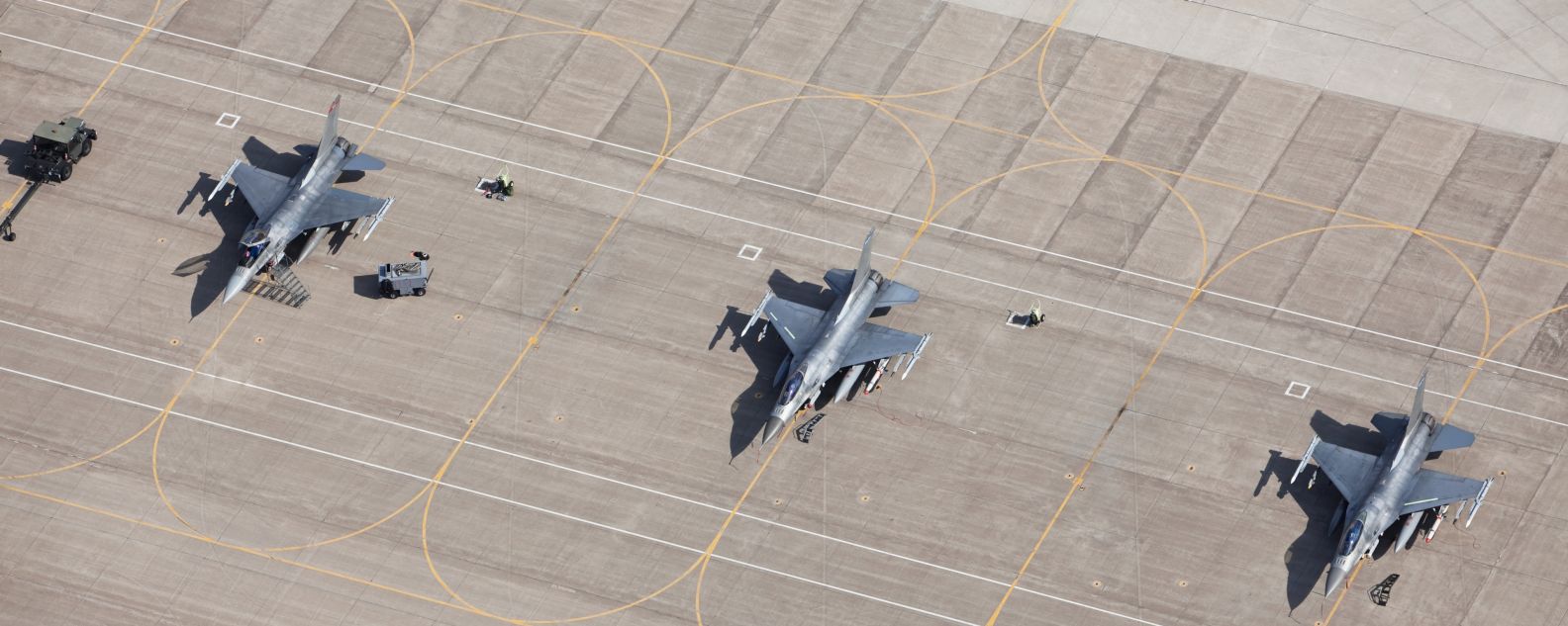 3機のF-16戦闘機が駐機場で飛行準備完了