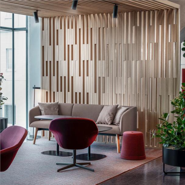 informal collaboration area with sofa and chairs in front of pattern wall