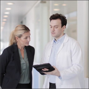 Businessperson and doctor looking at tablet