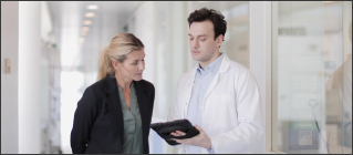 Businessperson and doctor looking at tablet