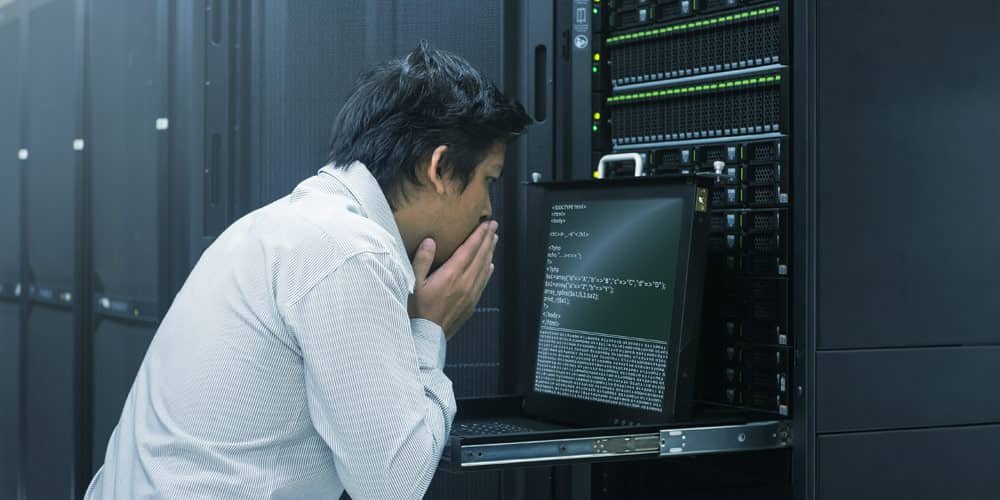 software engineer looking at code in data center
