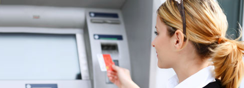 Person holding credit card at automatic teller machine