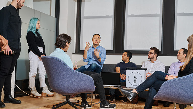 Group of people listening to a central speaker