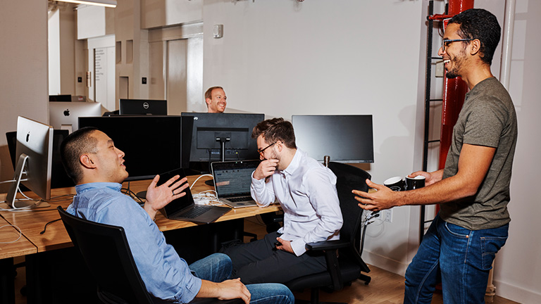 Group of people chatting and smiling at an office environment