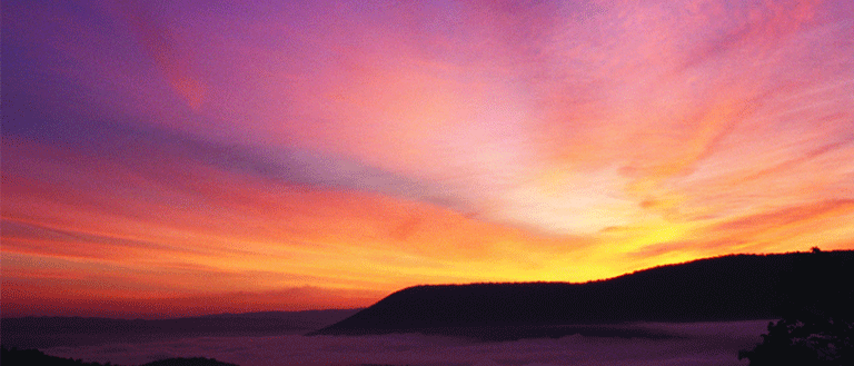 Blue, pink and yellow sunset over ocean shoreline