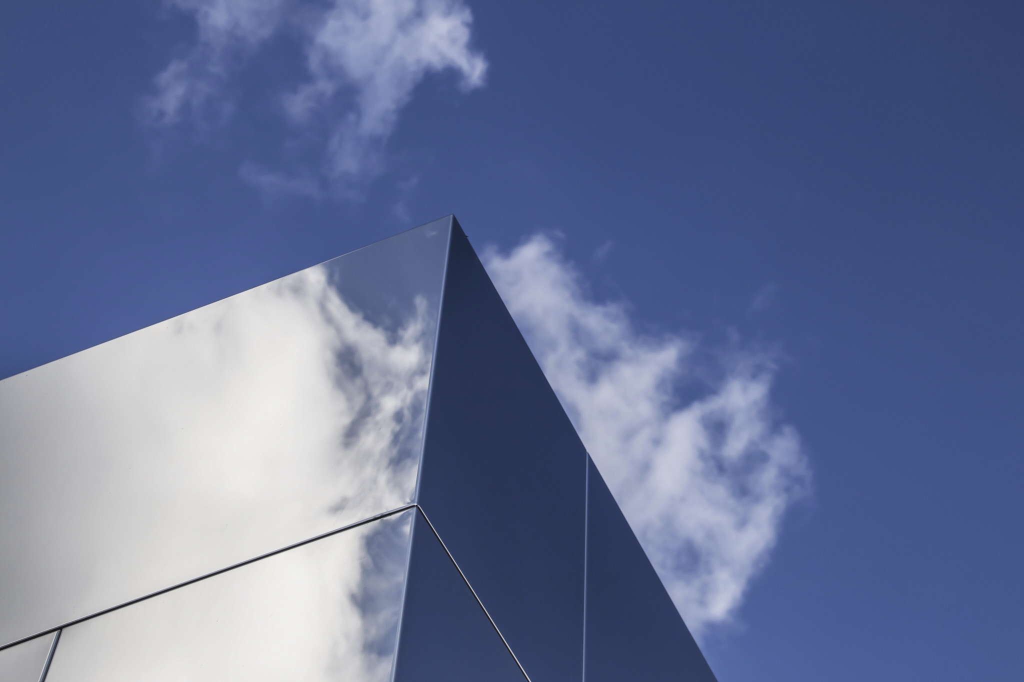 Top of office building against a blue sky with clouds